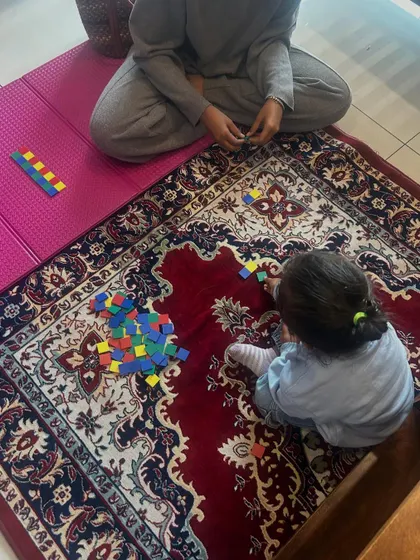 Pattern recognition is a key cognitive skill in early childhood. Here, two children are using colorful tiles to create and extend patterns. This simple, playful activity builds a strong foundation for logical thinking and mathematical reasoning.