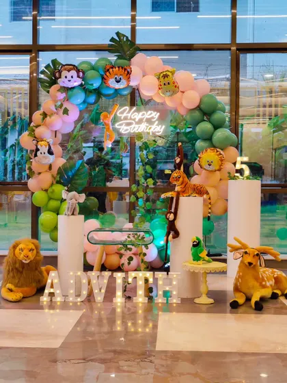 A simple yet effective jungle theme setup starting from just 9999. This shows that an aesthetic, themed party can be accessible, featuring a circular balloon arch and animal props.