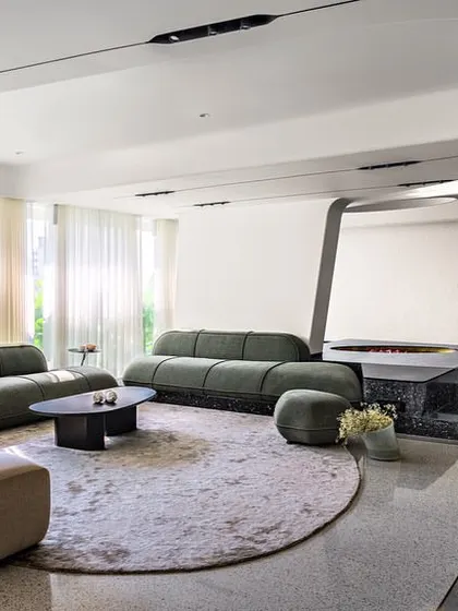 The living area in Apartment 56 is an open, gallery-like space with soft corners and sculptural furniture. We integrated existing columns as fluid spatial divisions, enhancing the design of the fluid interiors rather than concealing the structure.