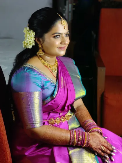 Pavitra seated, looking serene and beautiful. The pre-pleated saree drapes perfectly, allowing for comfort throughout the event.