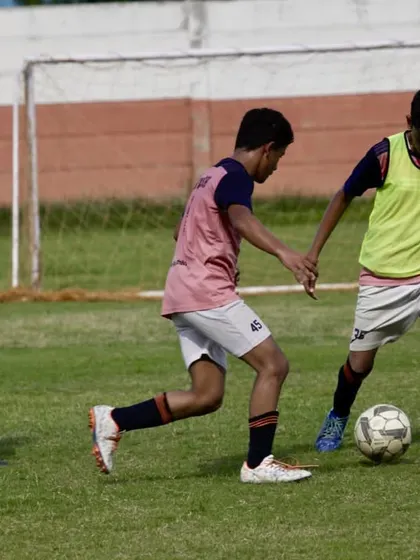 A group of players work together to move the ball up the field. This image captures the essence of teamwork and tactical play we instill in our teams.