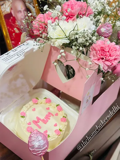 The perfect Mother's Day gift hamper. It features a custom 'Mum' bento cake in our signature pink box, paired with a beautiful bouquet of fresh carnations and glittery pink strawberry cake pops.