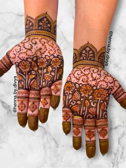 This design features a garden of flowers growing up the hand, creating a beautiful and organic pattern. The intricate details in each flower and leaf showcase the artistry involved.