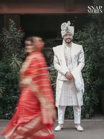 A creative shot using motion blur to capture the bride's movement, with the groom in sharp focus. We love experimenting with artistic techniques to make your wedding photos stand out.