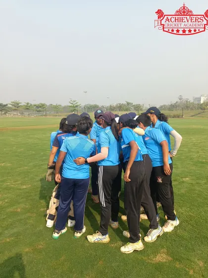 A team huddle before the match. Strategy, teamwork, and mutual support are pillars of our girls' cricket program.