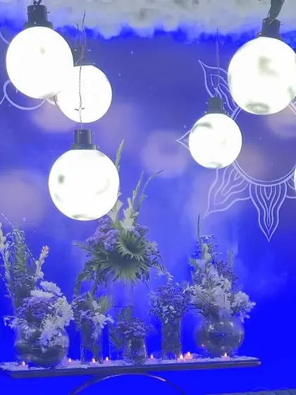 A detail of the celestial sangeet decor. Hanging moon-shaped lights and a blue color palette create a dreamy, night-sky atmosphere in the lounge area.