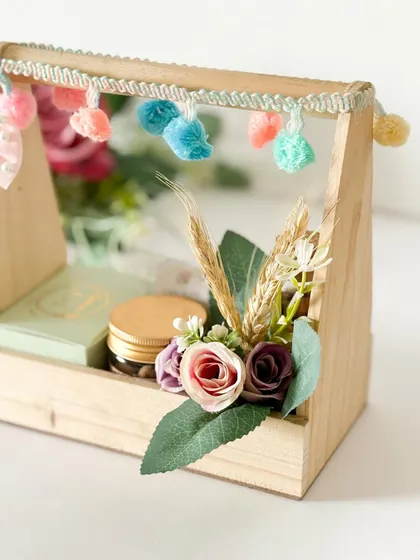 This whimsical wooden hamper with a pompom garland is another one of our unique options for baby announcements. It’s a gift that is both playful and elegant.