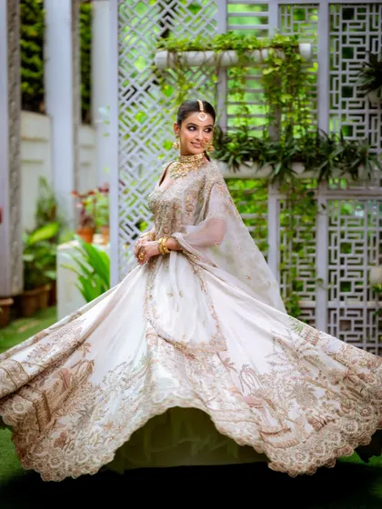 A dreamy, intense look that's perfect for your mood board. The bride is twirling in a magnificent embroidered lehenga, and her makeup features dramatic eyes and glowing skin to match the fairytale vibe.