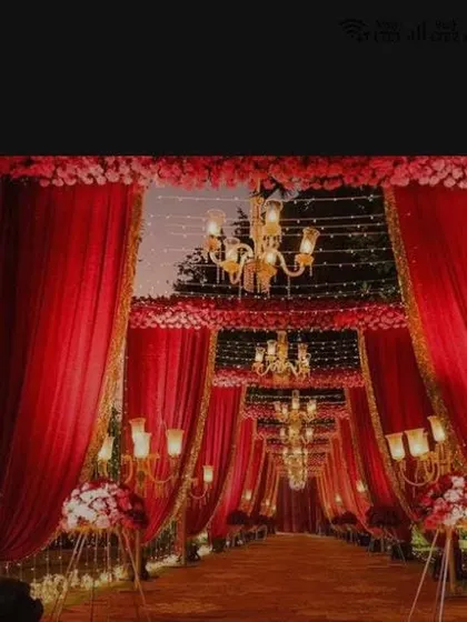 Red is the color of 'suhag' and multiplies happiness. This grand entrance tunnel made of red drapes and illuminated by chandeliers creates a dramatic and auspicious welcome for your guests.