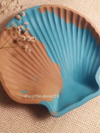 A close-up of our two-toned, sea-inspired clam shell dish. The blend of tan and blue evokes a peaceful day at the beach.