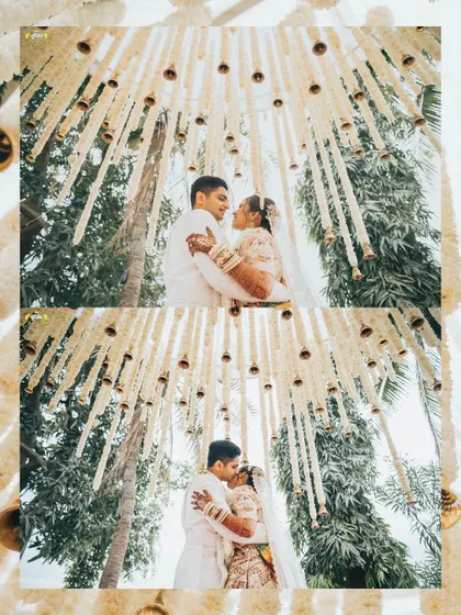 A creative shot looking up at the couple from below the hanging bells of the mandap. This unique perspective creates a magical and intimate frame for their embrace and kiss.