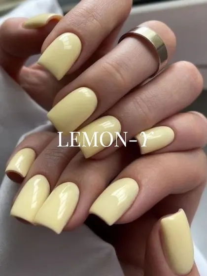 A soft, buttery lemon-yellow on square-shaped nails. This cheerful pastel shade is perfect for spring and summer, adding a touch of sunshine to your look.