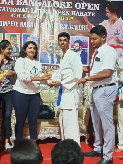 A student receiving his trophy on stage at the Sikka Bangalore Open, a proud moment for him and the school.