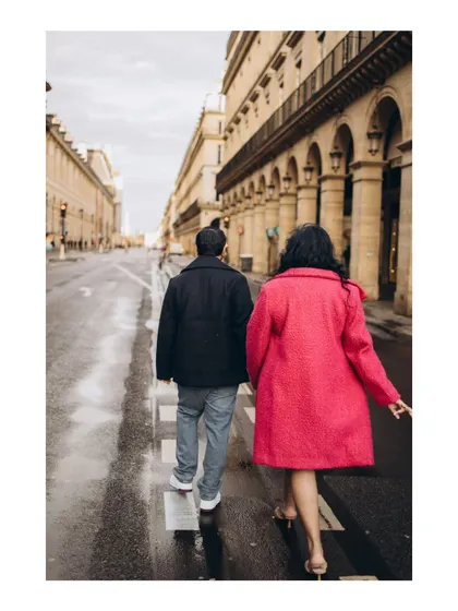 A candid walking shot capturing the couple's easy chemistry on the wet streets of Paris.