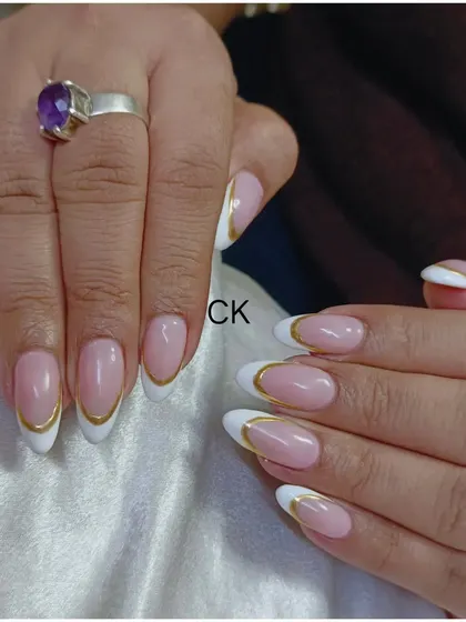 A close-up of the elegant French manicure with a gold chrome outline. This design is perfect for adding a touch of luxury to a classic look.
