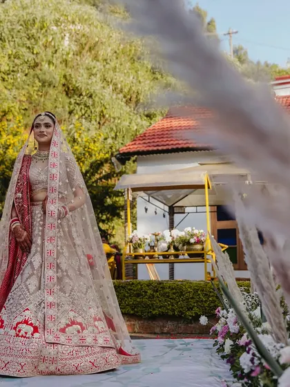 The bride's walk down the aisle at her childhood home in Ooty. We used the natural beauty of the location, adding pampas grass to frame her entrance perfectly.