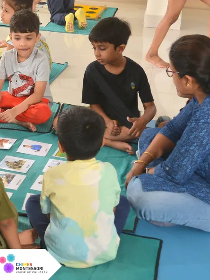 An educator sits with a group of children, observing and guiding their learning. This focused support ensures no child is overlooked.