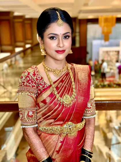 A classic South Indian bridal look featuring a bold red lip and defined eyes. This makeup style is perfect for the bride who wants to make a statement while looking traditionally elegant in her red and gold Kanjivaram.
