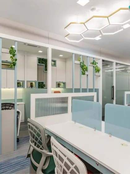 This shot shows the division between the open workspace and private cabins, achieved with glass and paneled partitions. This approach maintains an open feel while providing necessary privacy, and includes integrated planters for a touch of green.