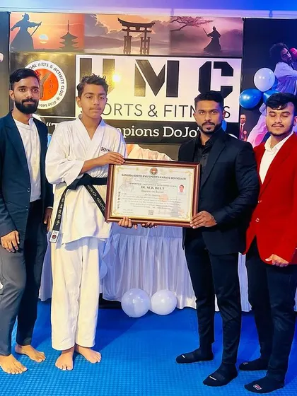 A student receives his black belt certificate from his coach, a culmination of years of hard work.