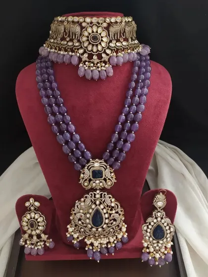A Victorian jewellery set with deep blue stones and beads. The design features peacock motifs on the choker and pendant, adding to its regal charm.