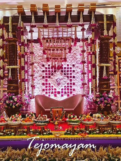A grand baby shower setup with a temple-style backdrop and an extensive display of offering plates, creating a divine and opulent look.