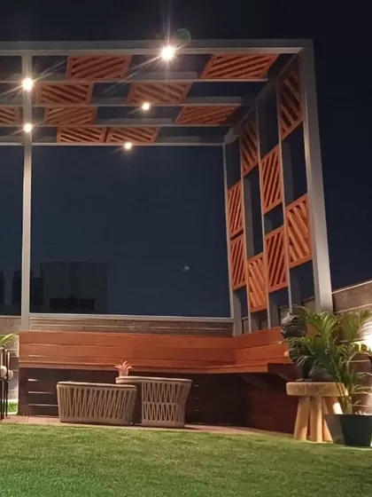 Another terrace handover in progress. This cozy setup features a custom pergola with integrated lighting, a built-in wooden bench, and all-weather furniture on artificial turf, creating a perfect evening spot.