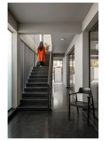 A view of the main circulation corridor and staircase. We used a simple palette of grey tones and allowed natural light to fill the space, ensuring that even transitional areas feel open and connected.