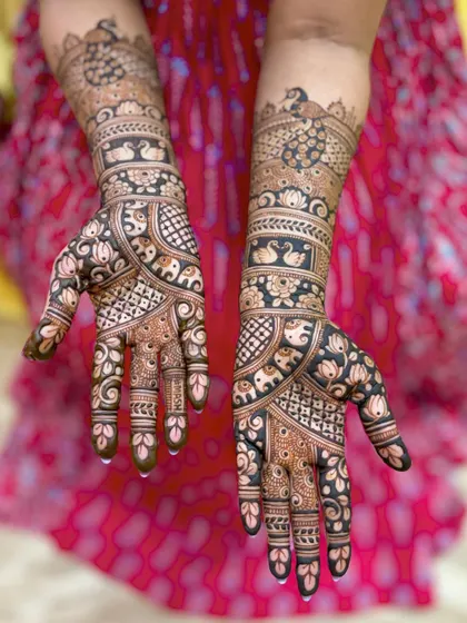 A beautiful bridal mehendi with a mix of peacocks, swans, elephants, and lotus motifs, creating a design that is full of life and symbolism.