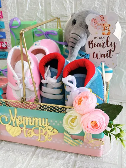 A detailed shot of the "We Can Bearly Wait" baby shower hamper. You can see the soft texture of the plush toy and the delicate flowers that add a touch of elegance.