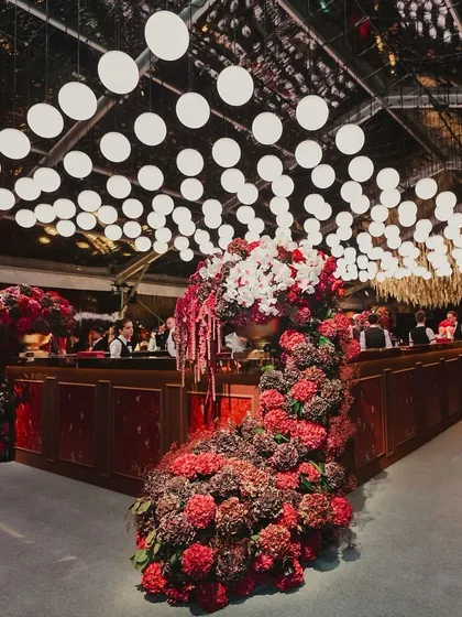 A look inside a glamorous red and maroon themed cocktail night, with velvet textures, a custom poker theme, and a stunning floral-decked bar.