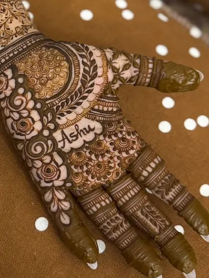 A close-up view of the name 'Ashu' integrated into the palm's design. It's a detail that makes the henna feel incredibly special and unique.