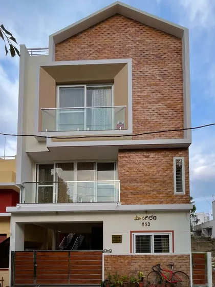 A photo of the completed Vinay's residence, showing how the design from the render was realized on site. The brick cladding and projecting balcony are key features.