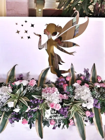 A stunning floral arrangement featuring a golden acrylic fairy cutout. This piece served as an elegant decor element at the entrance, combining fresh flowers with a touch of fairy magic.