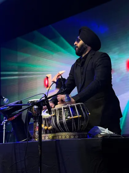 A focused, professional shot of me playing tabla on a dimly lit stage. This captures the intense and cool vibe of my club performances.