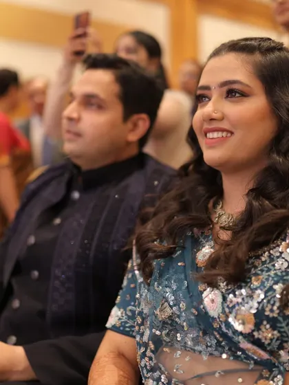 The happy couple enjoying the performances at their Sangeet, their smiles reflecting the joyous atmosphere of the event.