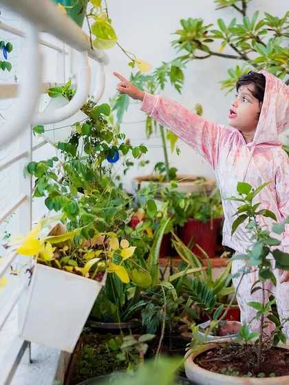The birthday girl exploring her balcony garden, pointing up with curiosity. We capture these simple, beautiful moments of childhood discovery.