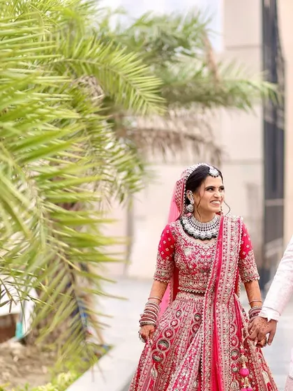 The couple shares a joyful, candid moment while walking together outdoors, their smiles lighting up this beautiful wedding day photograph.