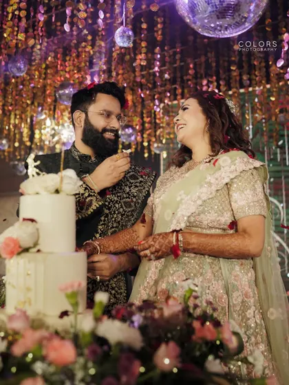 The couple cuts their wedding cake, surrounded by glittering decor and disco balls.