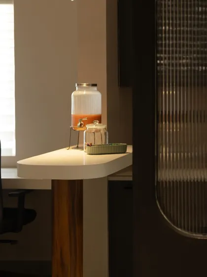 A close-up of the pantry's serving counter, highlighting the curved edge and the contrast between the white surface and wooden support.