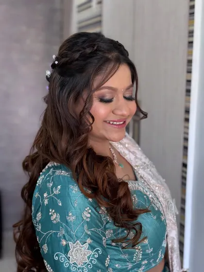A beautiful close-up of a soft glam look. The client is smiling, and her eyes are sparkling with a hint of teal shimmer.