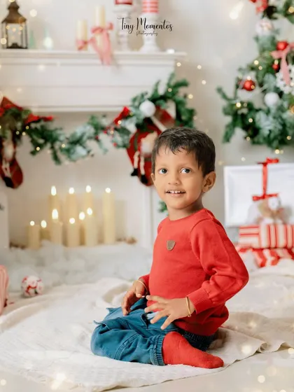 A quiet moment by the fireplace. This little one's sweet smile and the warm glow of the candles create a cozy and magical holiday atmosphere.