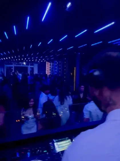 A serene moment under the blue lights, but the energy is still simmering, ready for the next drop.