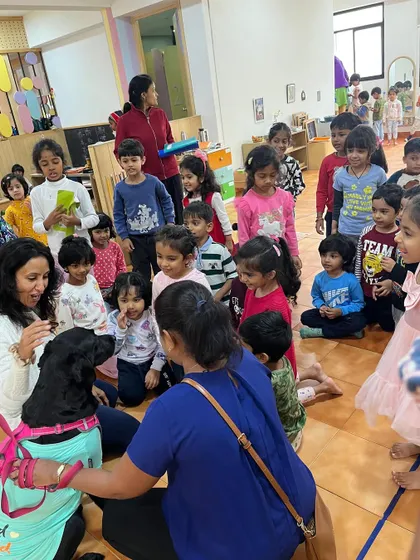 A wide view of the classroom shows how a pet visit brings the entire community together. It's a shared experience filled with joy and learning.