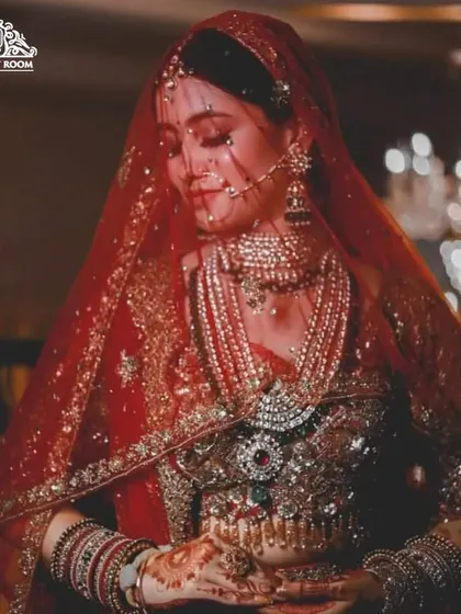 A beautiful, candid-style shot of a bride. The focus is on the rich colors of her attire and the complementary tones used in her makeup.