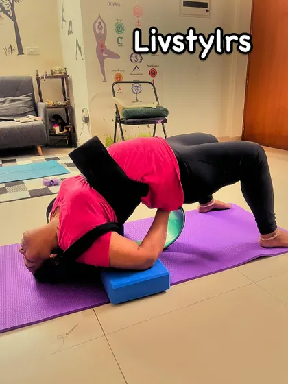 A client uses a yoga wheel and block for a supported backbend, a restorative pose that helps to release tension in the spine and open the chest.