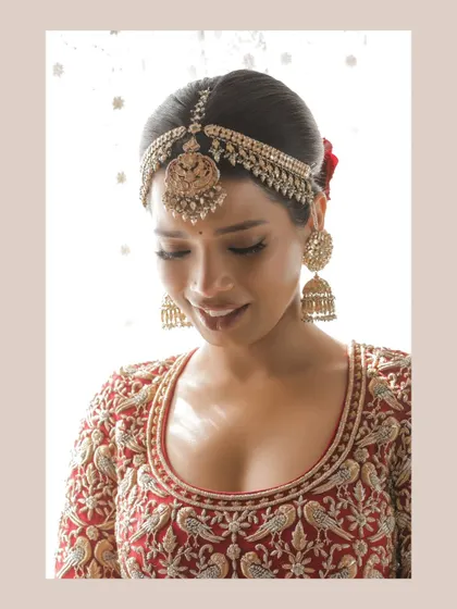 A close-up of the bride's smiling face, capturing her joy and beautiful traditional jewelry.