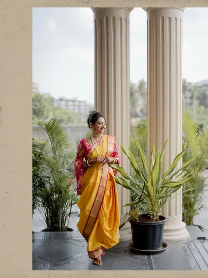 A full-length portrait of the bride walking with a smile, her vibrant saree flowing beautifully.