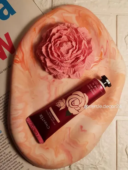 An oval cloud tray in a beautiful orange and pink marble finish. This piece is styled with a matching peony aroma diffuser and hand cream.