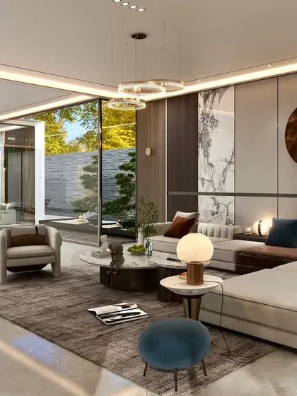An expansive view of an open-plan living area, showcasing how we use furniture groupings to create distinct zones. A large sectional defines the main lounge, while a separate, smaller seating arrangement is visible in the background, all unified by a consistent design language.